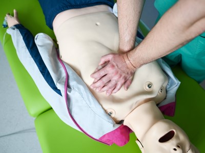 Bild zeigt medizinischen Mitarbeiter bei der Herzmassage an einem Dummy 